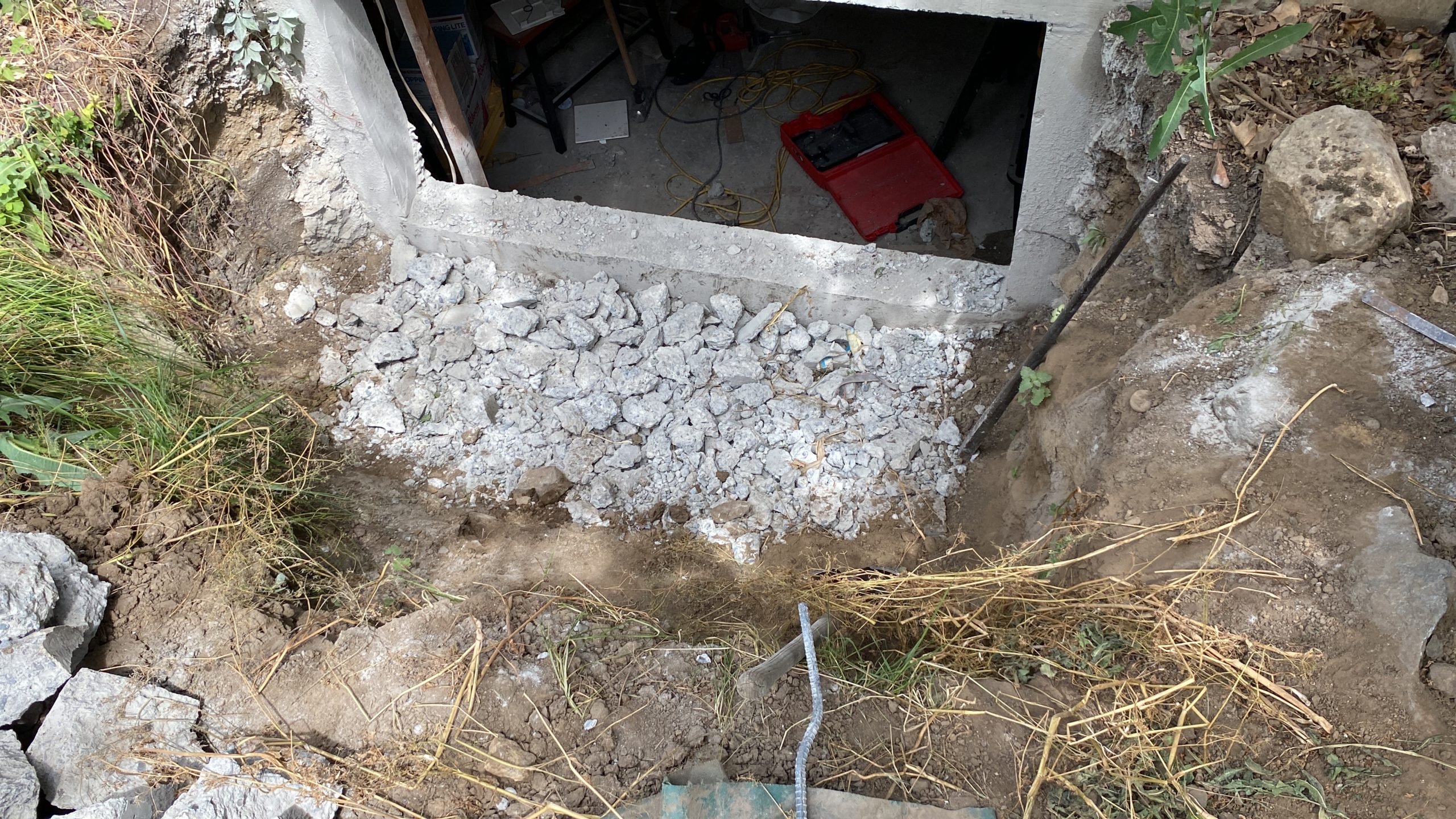 Below-grade excavation and masonry preparation outside a home